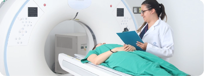 Profesional de salud acompañando a una paciente en un tomógrafo